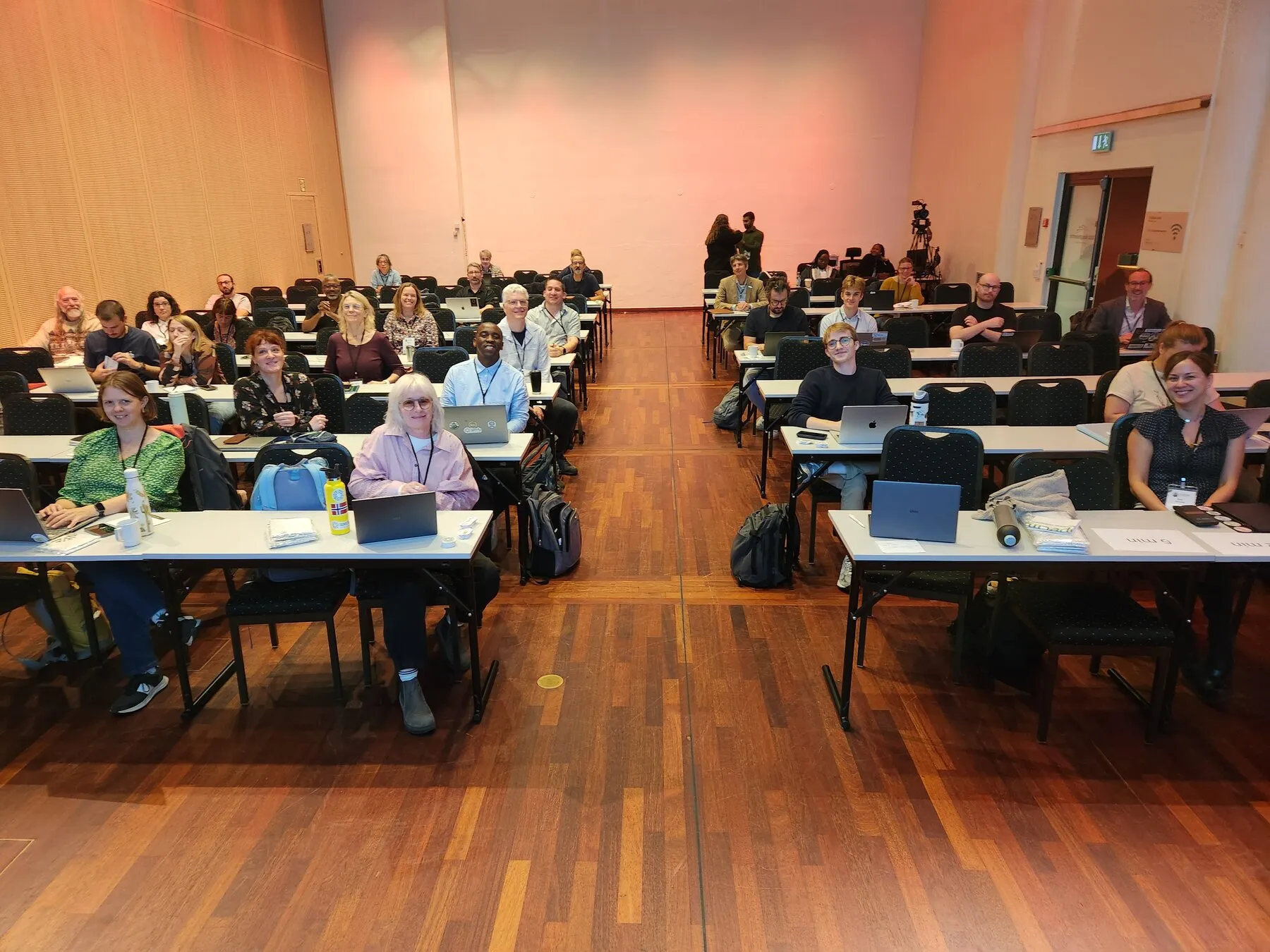 Attendees at tables in the auditorium during the Specify symposium