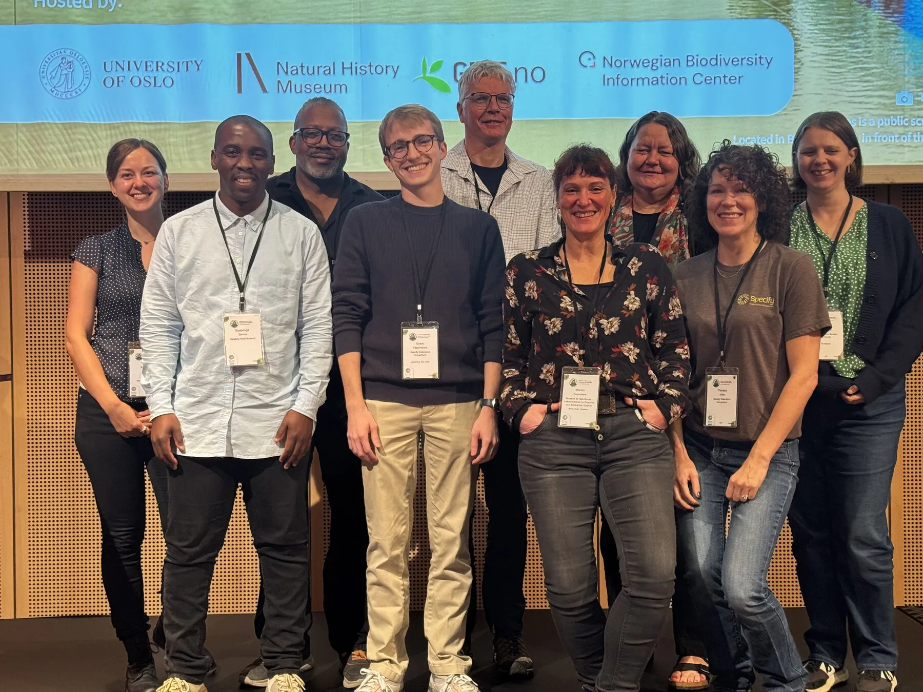 Grant and colleagues together in front of the symposium screen