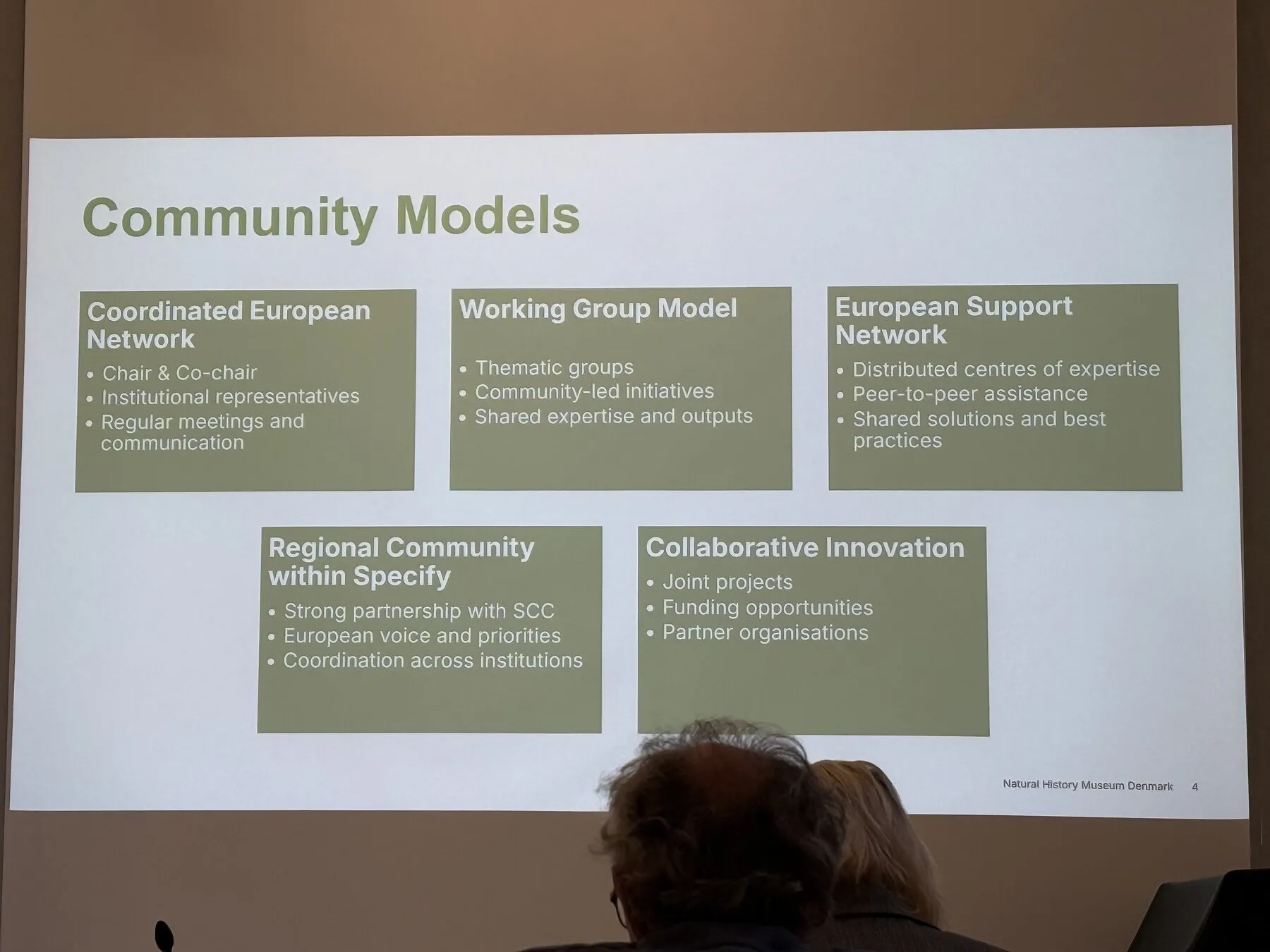 A projected slide comparing possible models for the European Specify community