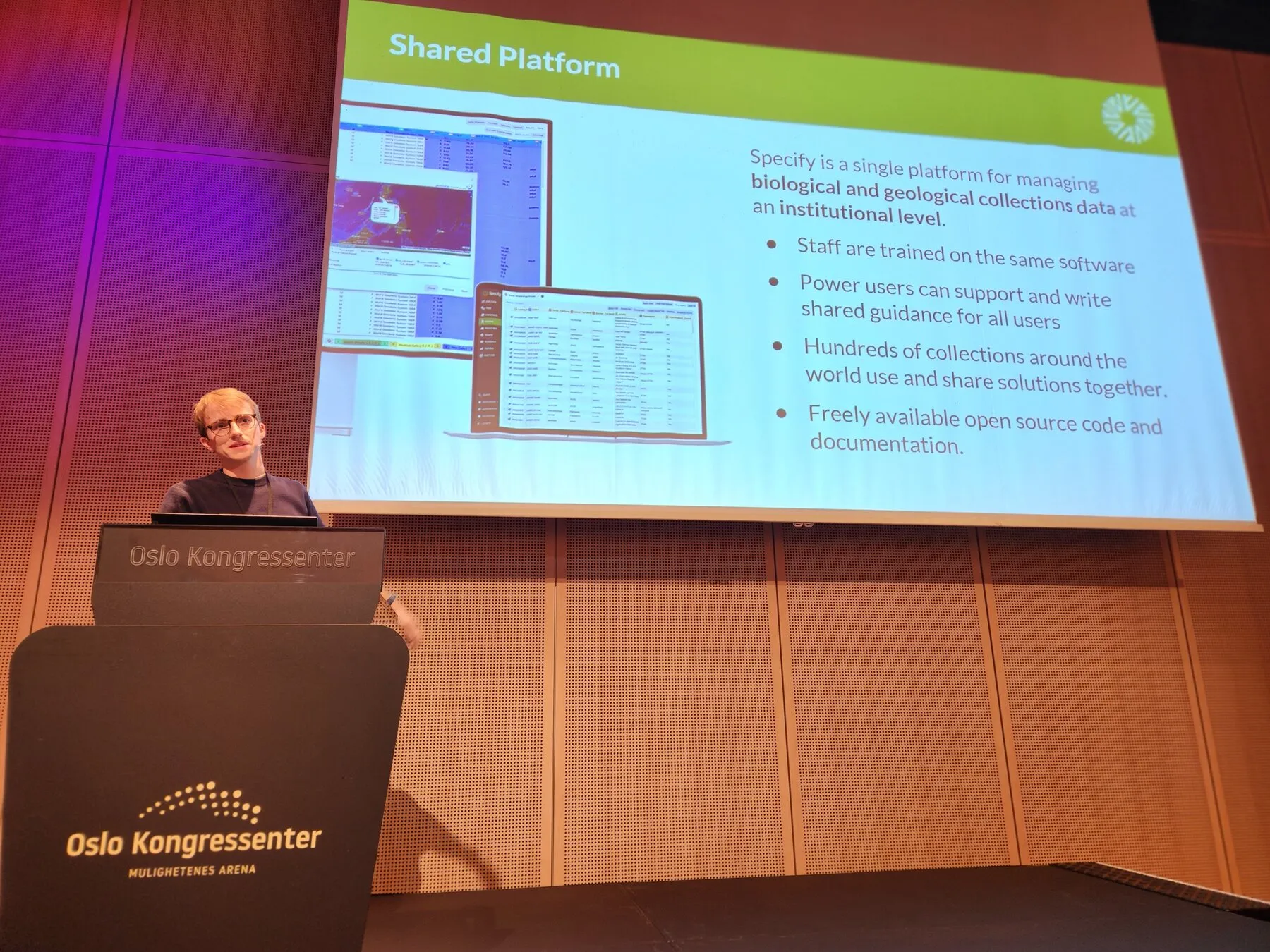 Grant speaking at the lectern with a Specify slide about shared patterns on the screen